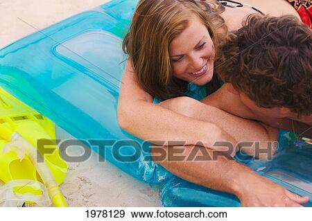 Stock Photo - Hawaii, Oahu, Kailua Beach, Couple Lay On Inflatable Rafts On The Beach.. Fotosearch