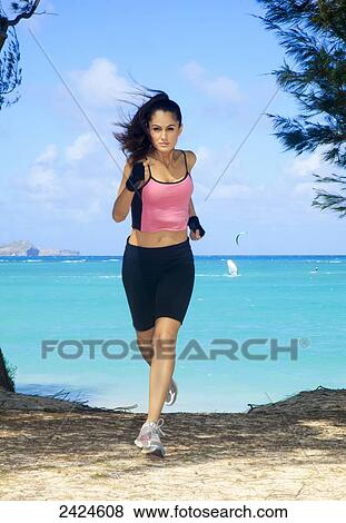 Stock Photo - Hawaii, Oahu, Kailua, Beautiful female running from beach.. Fotosearch