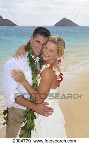 Stock Image - Hawaii, Oahu, Kailua, Lanikai Beach, Attractive Newlywed Couple On Beach.. Fotosearch