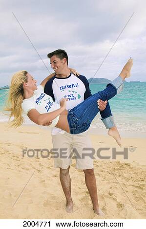 Stock Image - Hawaii, Oahu, Kailua, Lanikai Beach, Attractive Newlywed Couple On Beach.. Fotosearch
