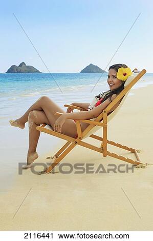 Stock Image - Hawaii, Oahu, Kailua, Lanikai, Beautiful woman lounges on a remote beach.. Fotosearch