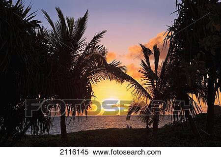 Stock Photography - Hawaii, Oahu, Kailua, Lanikai, Vibrant sunset with a couple on beach.. Fotosearch