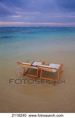 Stock Image - Hawaii, Oahu, Kailua, Two lounge chairs on the white sandy beach of Lanikai.. Fotosearch