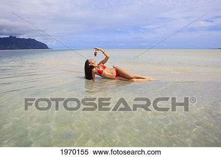 Stock Photography - Hawaii, Oahu, Kaneohe Bay, Woman Eating Grapes On The Sandbar. Fotosearch