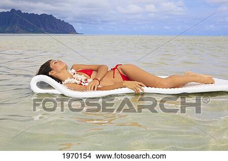 Picture - Hawaii, Oahu, Kaneohe Bay, Woman Floating On A Raft At The Sandbar. Fotosearch