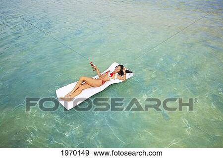 Hawaii, Oahu, Kaneohe Bay, Woman Floating On A Raft With A Tropical Drink View Large Photo Image Stock Photo - Hawaii, Oahu, Kaneohe Bay, Woman Floating On A Raft With A Tropical Drink. Fotosearch