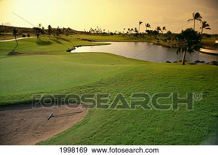 Hawaii, Oahu, Kapolei, Ko'olina Golf Club, 18Th Hole At Twilight, Water Hazard, Sand Trap A18F View Large Photo Image Stock Photo - Hawaii, Oahu, Kapolei, Ko'olina Golf Club, 18Th Hole At Twilight, Water Hazard, Sand Trap A18F. Fotosearch