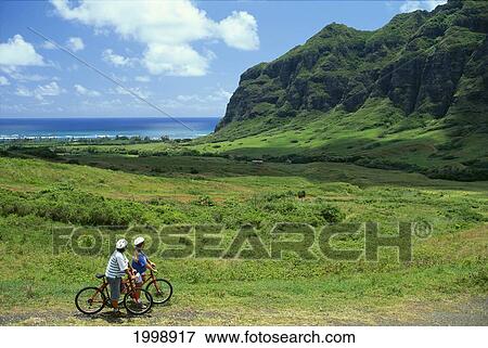 Stock Photo - Hawaii, Oahu, Kualoa Ranch, Couple Riding Bicycles. Fotosearch