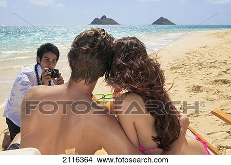 Hawaii, Oahu, Lanikai, A beachboy takes a picture of a young couple on the beach. View Large Photo Image Picture - Hawaii, Oahu, Lanikai, A beachboy takes a picture of a young couple on the beach.. Fotosearch