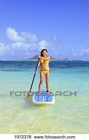 Stock Photo - Hawaii, Oahu, Lanikai, Asian Women Paddle Boarding Off The Beach Near Mokulua Island.. Fotosearch