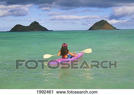 Stock Image - Hawaii, Oahu, Lanikai, Back View Of Woman In Pink Kayak, Clear Water, Yellow Paddles, Pink Lei, Blue Sky. Fotosearch