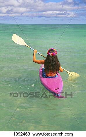 Stock Image - Hawaii, Oahu, Lanikai, Back View Of Woman In Pink Kayak, Clear Water, Yellow Paddles, Pink Lei, Blue Sky. Fotosearch