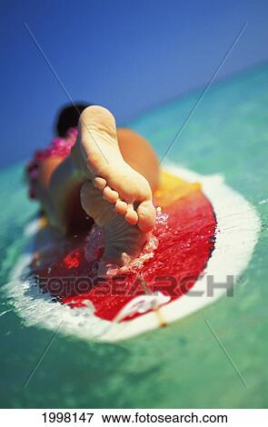 Stock Photo - Hawaii, Oahu, Lanikai Beach, Close-Up View From Feet Of Woman With Lei Lying On Surfboard. Fotosearch