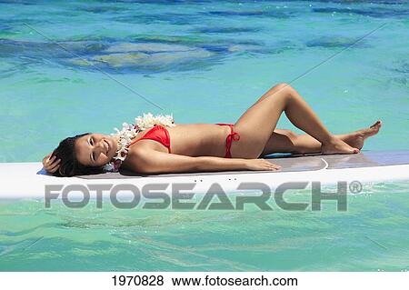 Stock Photo - Hawaii, Oahu, Lanikai Beach, Girl Floating On Surfboard, Mokulua Islets In Background.. Fotosearch