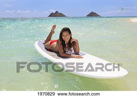 Stock Photo - Hawaii, Oahu, Lanikai Beach, Girl Floating On Surfboard, Mokulua Islets In Background.. Fotosearch
