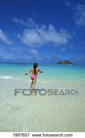 Stock Photo - Hawaii, Oahu, Lanikai Beach, Mokulua Islands, Girl Running Into Ocean, Blue Sky Hawaii. Fotosearch