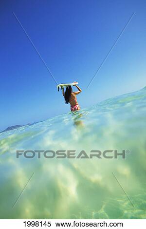 Hawaii, Oahu, Lanikai Beach, Over/Under View Of Woman Holding Surfboard On Head View Large Photo Image Stock Photography - Hawaii, Oahu, Lanikai Beach, Over/Under View Of Woman Holding Surfboard On Head. Fotosearch