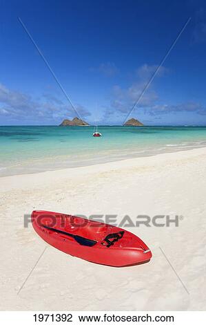 Stock Image - Hawaii, Oahu, Lanikai Beach, Red Kayak On Sandy Shore, Mokulua Islands In Distance.. Fotosearch