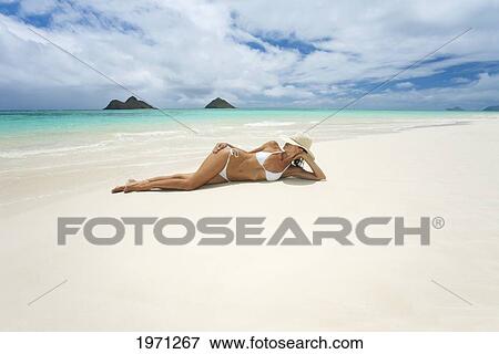 Stock Photo - Hawaii, Oahu, Lanikai Beach, Woman Relaxing Along Sandy Shore.. Fotosearch