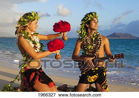 Stock Photo - Hawaii, Oahu, Lanikai Beach, Young Couple Dancing Hula On Beach, Sunrise Light.. Fotosearch