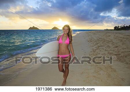Stock Photograph - Hawaii, Oahu, Lanikai, Blond Surfer Girl With Surfboard Along Beach.. Fotosearch