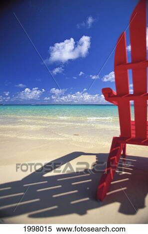 Stock Photography - Hawaii, Oahu, Lanikai, Close-Up View From Behind Red Adirondack, Shadow On Shore Line, Calm Turquoise Ocean Shoreline. Fotosearch