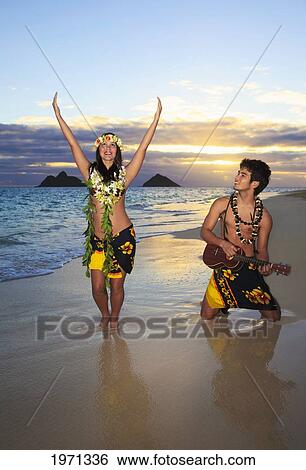 Stock Photograph - Hawaii, Oahu, Lanikai, Hula Dancer Couple Along Beach Shoreline At Sunrise.. Fotosearch