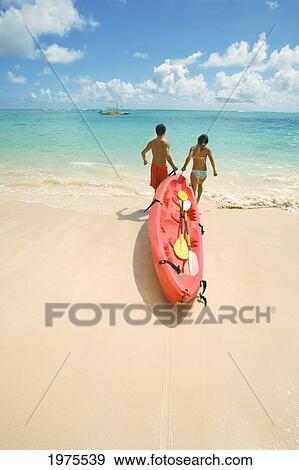 Hawaii, Oahu, Lanikai, Japanese Couple Pulling A Kayak To The Ocean. View Large Photo Image Stock Photo - Hawaii, Oahu, Lanikai, Japanese Couple Pulling A Kayak To The Ocean.. Fotosearch