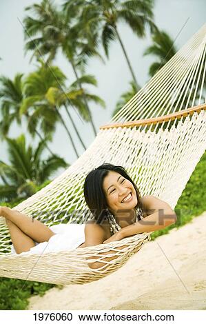 Stock Image - Hawaii, Oahu, Lanikai, Japanese Woman In Hammock.. Fotosearch