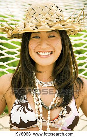 Stock Image - Hawaii, Oahu, Lanikai, Japanese Woman In Hammock With Straw Hat.. Fotosearch