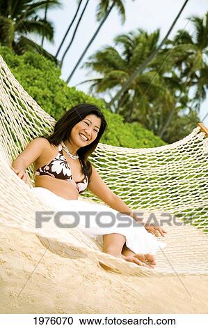 Stock Image - Hawaii, Oahu, Lanikai, Japanese Woman In Hammock.. Fotosearch