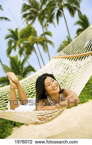 Stock Image - Hawaii, Oahu, Lanikai, Japanese Woman In Hammock.. Fotosearch