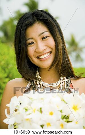 Hawaii, Oahu, Lanikai, Japanese Woman Holding Plumeria Flowers. View Large Photo Image Stock Photo - Hawaii, Oahu, Lanikai, Japanese Woman Holding Plumeria Flowers.. Fotosearch