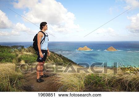 Hawaii, Oahu, Lanikai, Male Hiker Admiring View Of Mokulua Islands. View Large Photo Image Stock Image - Hawaii, Oahu, Lanikai, Male Hiker Admiring View Of Mokulua Islands.. Fotosearch