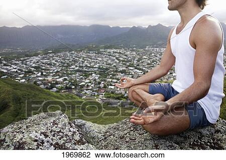 Stock Image - Hawaii, Oahu, Lanikai, Male Hiker Admiring View Of Doing Yoga At The Top Of The Pill Box Hike.. Fotosearch