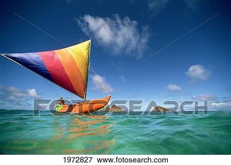 Hawaii, Oahu, Lanikai, Man In Colorful Sailing Canoe. View Large Photo Image Stock Photo - Hawaii, Oahu, Lanikai, Man In Colorful Sailing Canoe.. Fotosearch