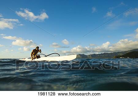 Stock Photo - Hawaii, Oahu, Lanikai, Man Paddling One Man Outrigger Canoe, Land In Background.. Fotosearch