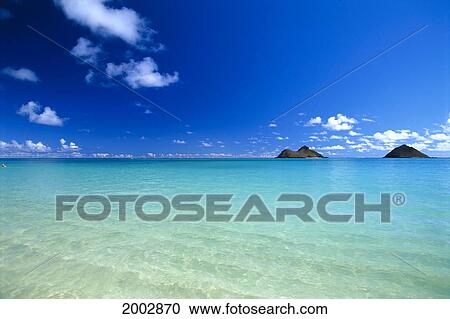 Stock Image - Hawaii, Oahu, Lanikai, Shallow Water Fades To Turquoise, Mokulua Islands In Background. Fotosearch