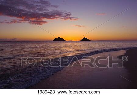 Stock Image - Hawaii, Oahu, Lanikai, Sunrise With The Mokolua Islands In The Distance.. Fotosearch