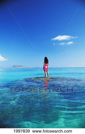 Stock Photo - Hawaii, Oahu, Lanikai, Woman Standing On Reef With Lei Looking Toward Kaneohe Bay. Fotosearch