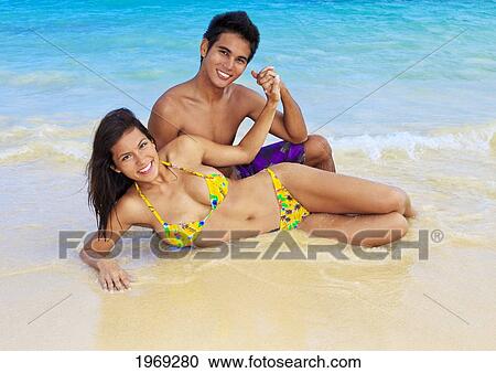 Stock Image - Hawaii, Oahu, Lanikai, Young Couple On The Beach.. Fotosearch