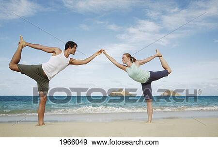 Stock Photo - Hawaii, Oahu, Lanikai, Young Couple Hold A Yoga Position On The Beach.. Fotosearch