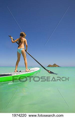 Stock Image - Hawaii, Oahu, Lanikai, Young Girl Stand Up Paddling.. Fotosearch