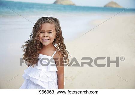 Stock Image - Hawaii, Oahu, Lanikai, Young Girl Smiles At Camera On Beach.. Fotosearch