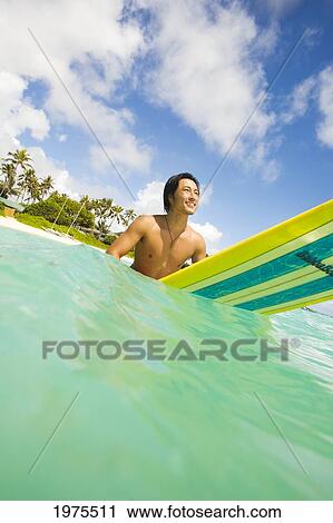 Hawaii, Oahu, Lanikai, Young Japanese Man Sitting On Surfboard In The Ocean. View Large Photo Image Stock Image - Hawaii, Oahu, Lanikai, Young Japanese Man Sitting On Surfboard In The Ocean.. Fotosearch