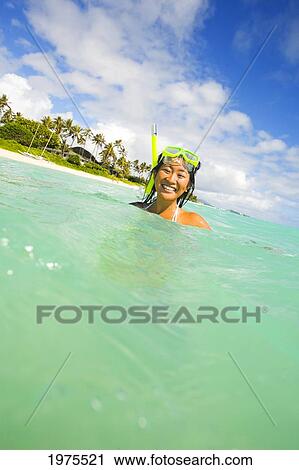 Stock Image - Hawaii, Oahu, Lanikai, Young Japanese Woman Wearing Snorkle Gear In The Ocean.. Fotosearch