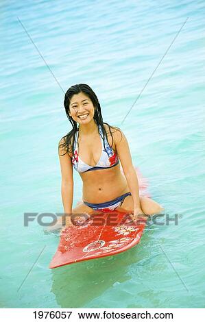Stock Photo - Hawaii, Oahu, Lanikai, Young Japanese Woman Sitting On Surfboard.. Fotosearch