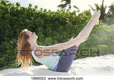 Stock Image - Hawaii, Oahu, Lanikai, Young Woman Does Yoga On The Beach.. Fotosearch