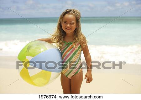 Picture - Hawaii, Oahu, Little Girl Poses On Beach With Beach Ball.. Fotosearch