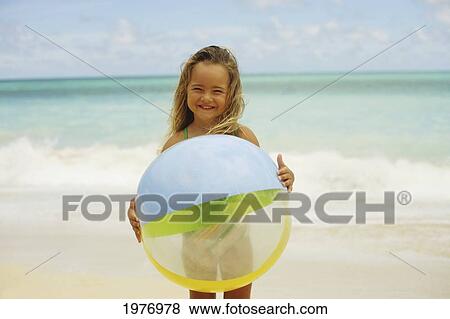 Stock Photo - Hawaii, Oahu, Little Girl Poses On Beach With Beach Ball.. Fotosearch